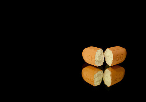 broken pill on black background