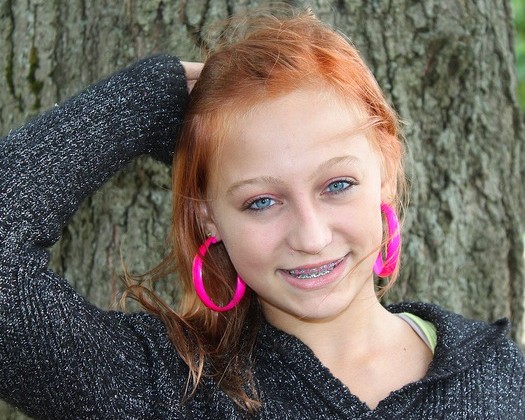 teen girl smiling against tree